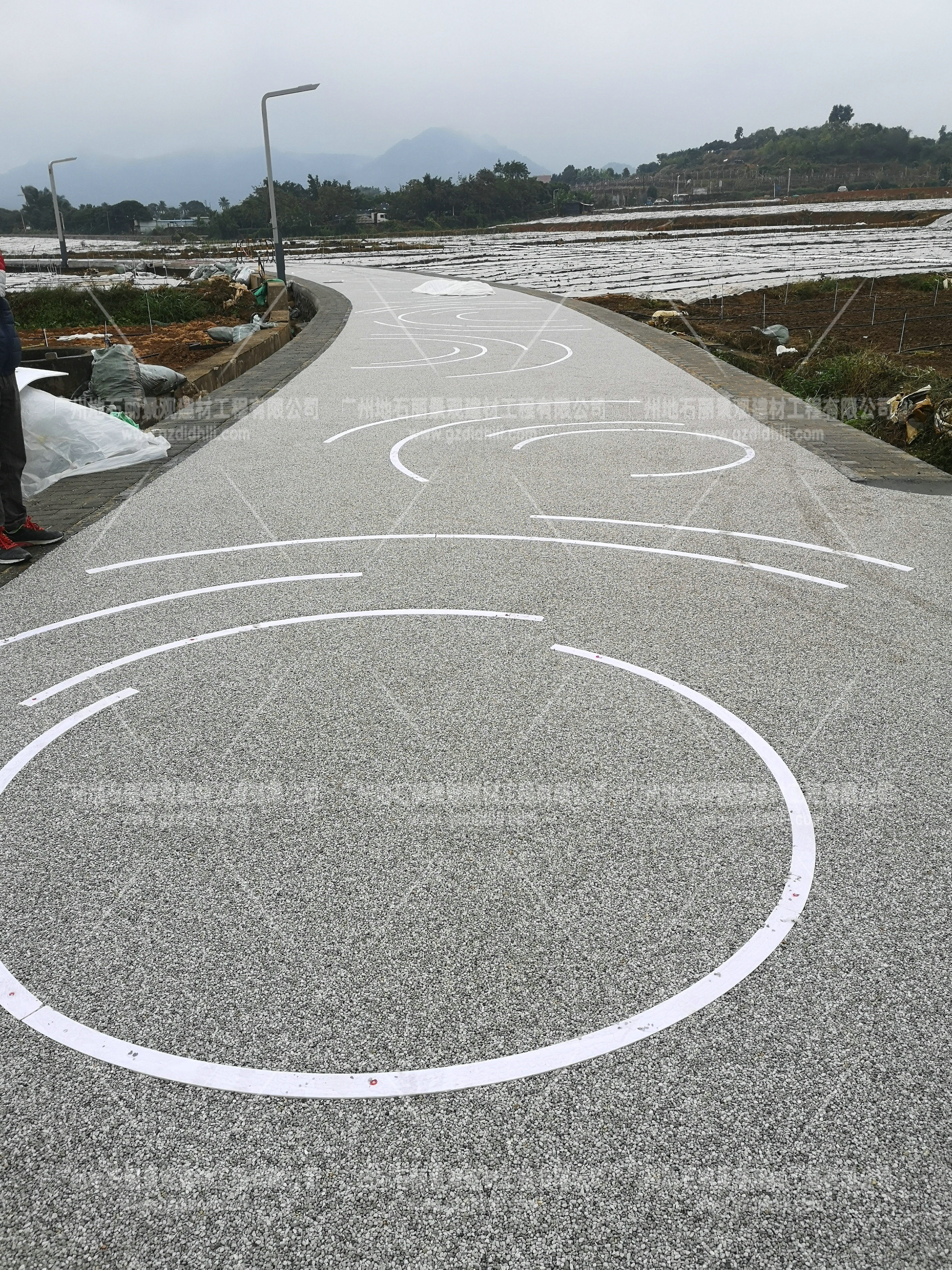 海綿城市透水發(fā)光石子膠粘石路面。深圳光明新區(qū)綠道支線段發(fā)光路面農田段